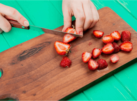 Women cutting strawberries